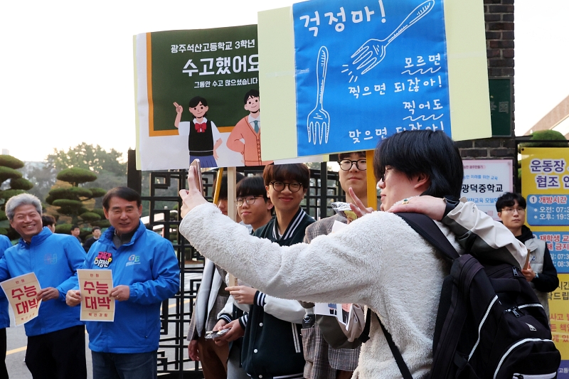  Los estudiantes de secundaria de grados inferiores animan a los estudiantes de último año frente a la Escuela Secundaria Gwangdeok antes de que comience, en dicho lugar, el examen nacional de acceso a la universidad, el 14 de noviembre, en el distrito Seou-gu de la ciudad de Gwangju.