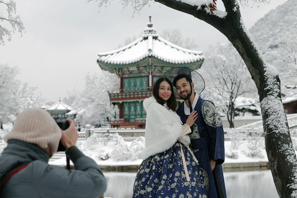 La foto muestra a una pareja de turistas vestidos con el traje tradicional coreano hanbok posando para fotos el 27 de noviembre en el palacio Gyeongbokgung, ubicado en el distrito de Jongno-gu, en Seúl. | Lee Jun Young