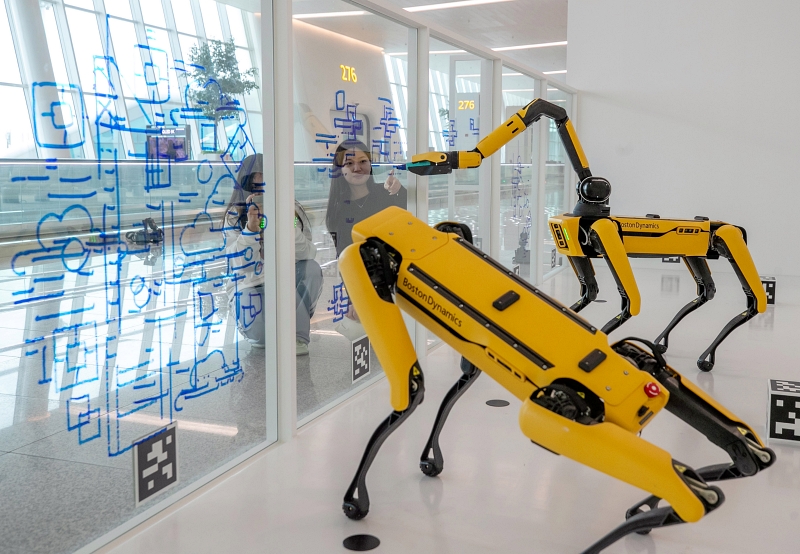 Dos viajeras observan los robots que dibujan en el cristal de una ventana de la Terminal 2 del Aeropuerto de Incheon el 16 de diciembre. Esta exposición especial de robots cuadrúpedos estará abierta durante seis meses de las 8:00 a.m. a las 8:00 p.m.