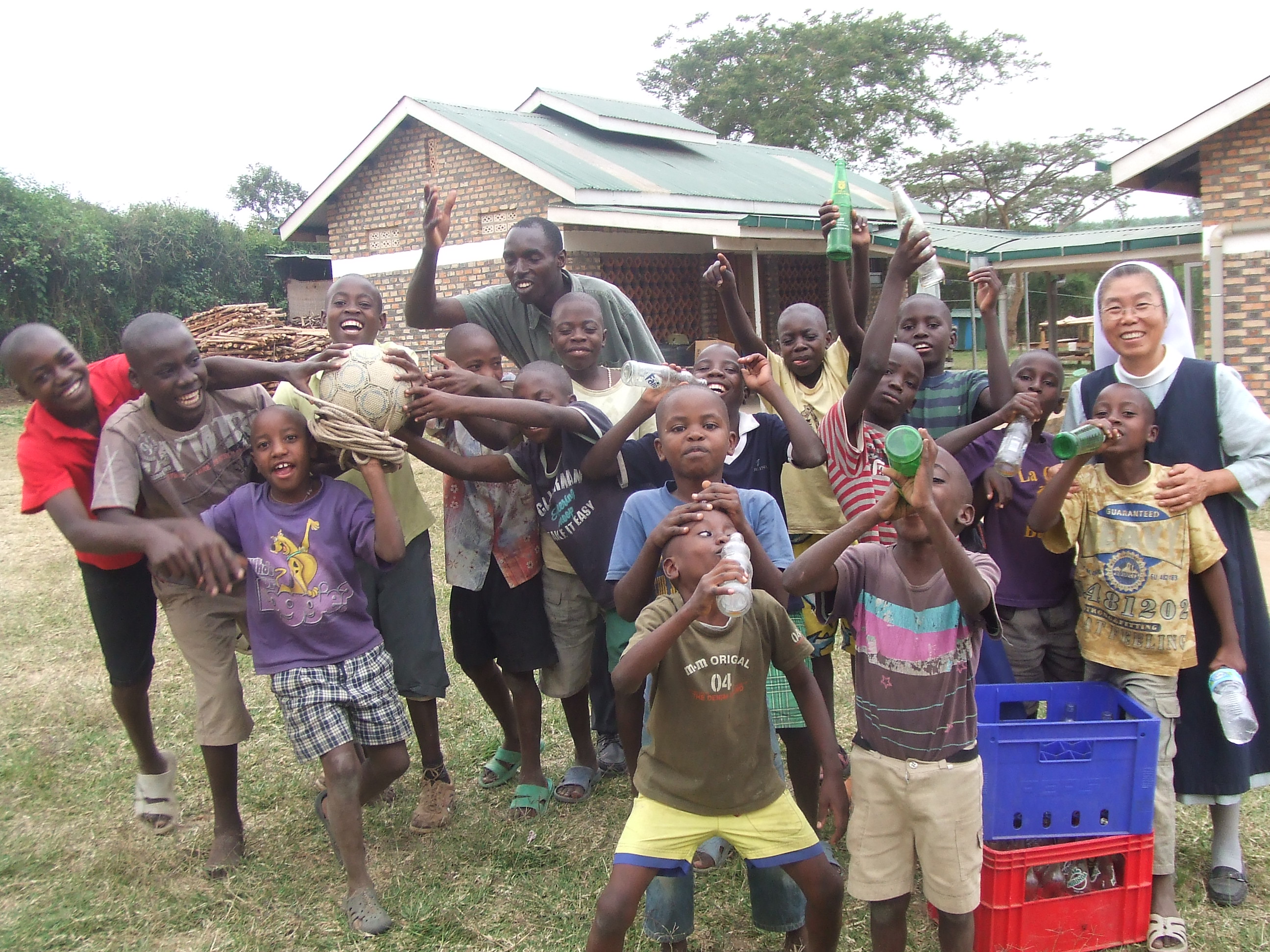 La hermana Hwang Kyung Soon posa con unos niños ugandeses.