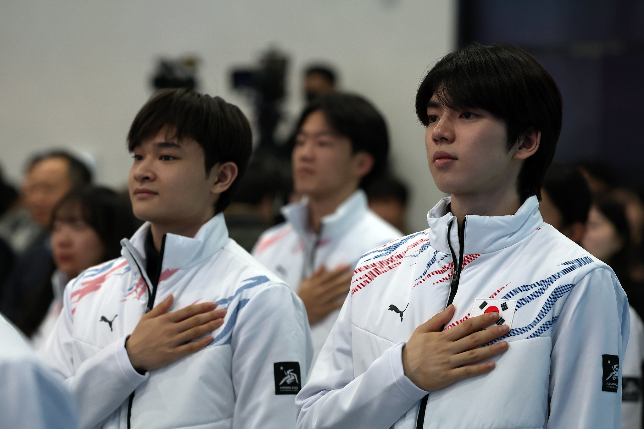 Los patinadores artísticos Cha Jun-hwan (derecha) y Kim Hyun-gyeom rinden homenaje a la bandera nacional durante la ceremonia de presentación del equipo coreano para los Juegos Asiáticos de Invierno Harbin 2025, celebrada el 24 de enero en el hotel Olympic Parktel en el distrito de Songpa-gu, Seúl.