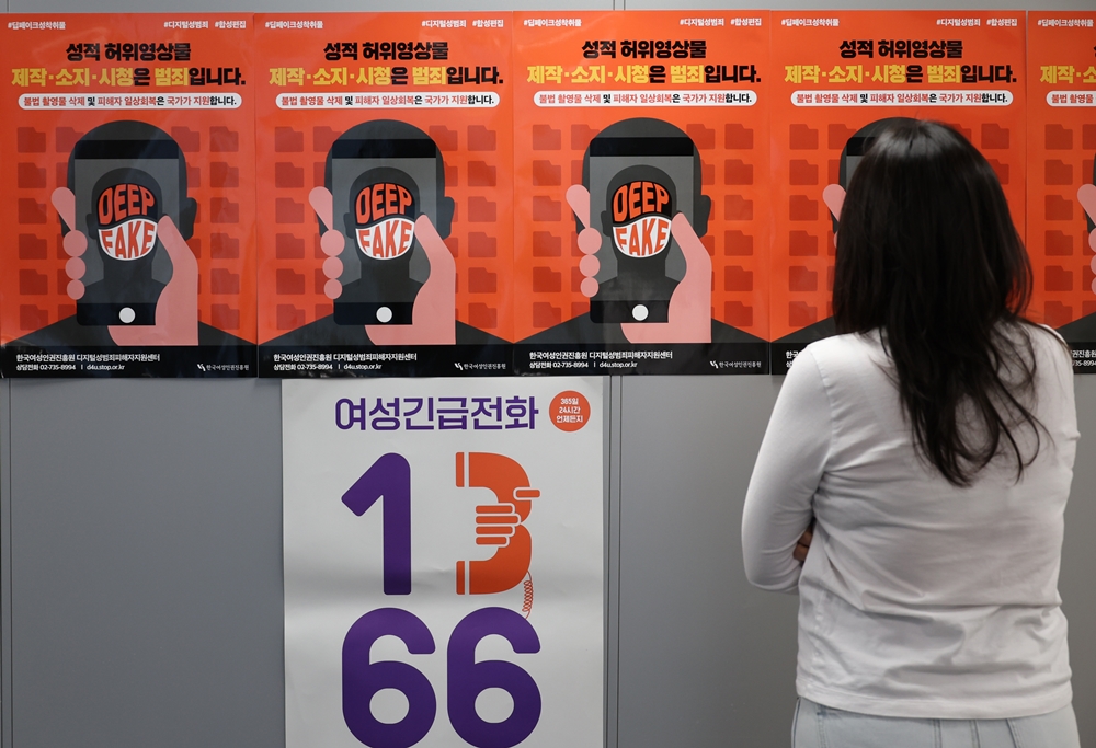 Una mujer mira los pósteres que promueven la prevención de los delitos de deepfake, en noviembre de 2023, en el centro para víctimas de delitos sexuales digitales del Instituto de Derechos Humanos de la Mujer de Corea, en Seúl. | Agencia de Noticias Yonhap 