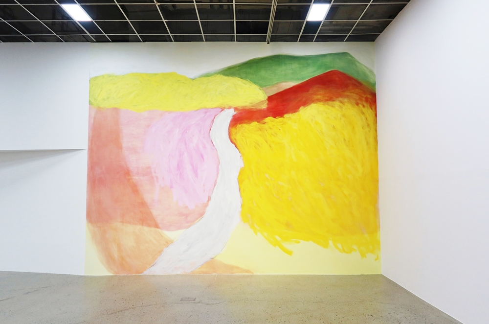 En la entrada de la exposición 'Colores de agua' en la sede de Cheongju del Museo Nacional de Arte Moderno y Contemporáneo (MMCA, por sus siglas en inglés), se encuentra el mural 'Asan' (2025) de Yoon Jongsuk, una obra creada sin boceto previo que plasma de manera intuitiva los paisajes del pueblo natal de la artista, Asan, provincia de Chungcheongnam-do. | Charles Audouin