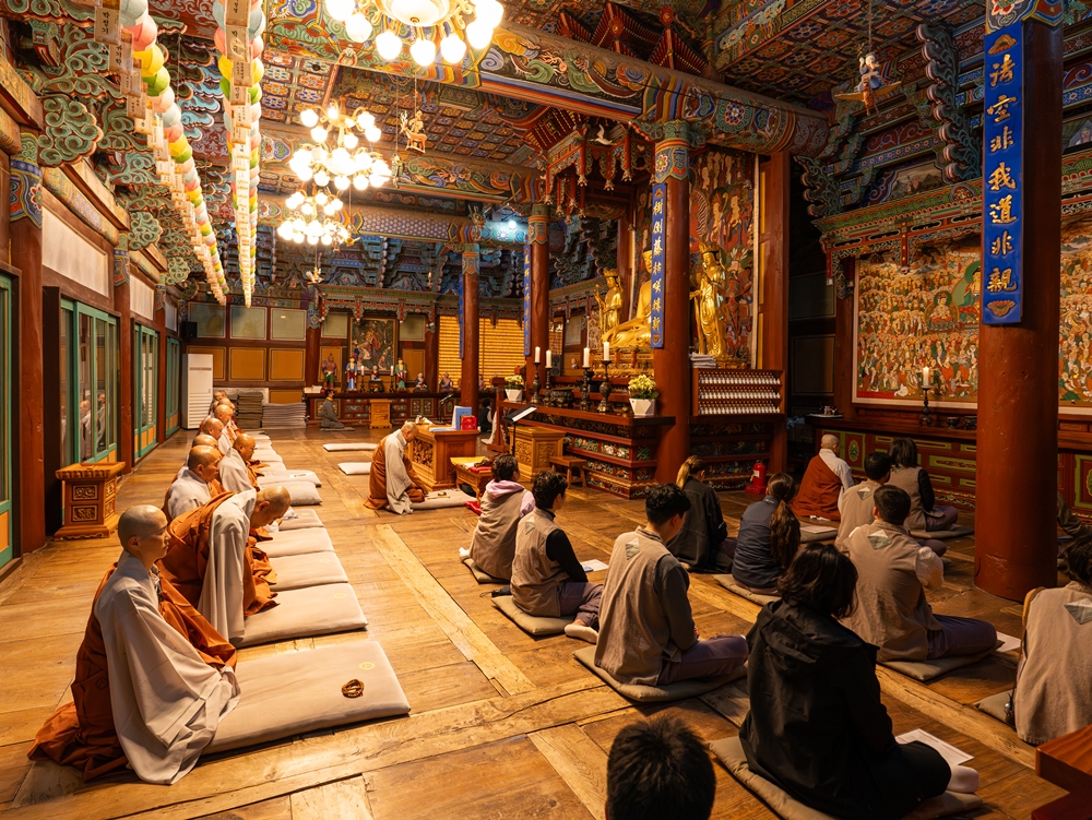 Los monjes y los periodistas visitantes participaron en el rezo matutino del 3 de mayo en el Daewoongjeon, el edificio principal del templo decorado con dancheong, un estilo tradicional de pintura arquitectónica coreana.