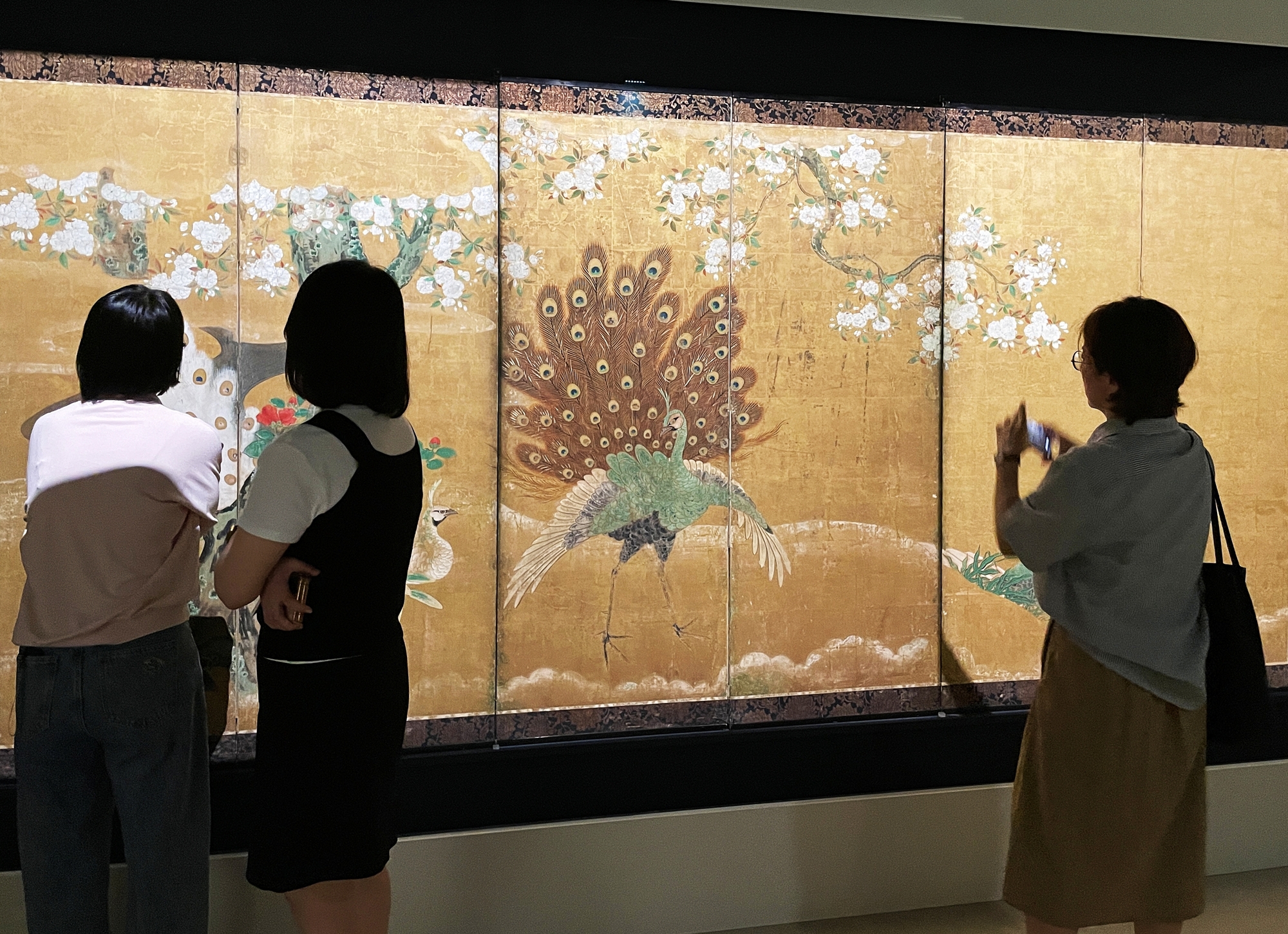Unas visitantes observan un biombo decorado con un fénix y un pavo real durante un evento para la prensa con motivo de la inauguración de la exposición 'El arte japonés desde cuatro perspectivas', el 16 de junio, en el Museo Nacional de Corea en Seúl.