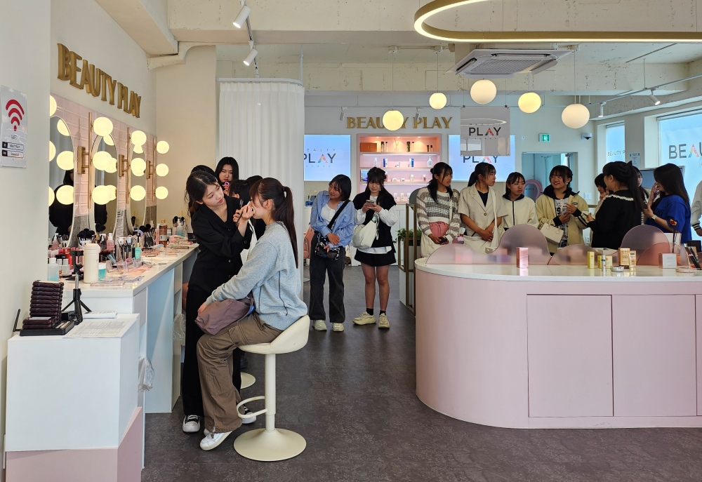El Ministerio de Cultura, Deportes y Turismo organiza el Korea Beauty Festival 2025 del 19 de junio al 18 de julio, en conjunto con el Comité Visit Korea y la Organización de Turismo de Corea. La foto muestra a unas turistas extranjeras participando en una sesión de maquillaje en Beauty Play Hongdae (centro de exhibición e interacción cosmética) en la zona de la Universidad de Hongik, en Seúl, en mayo del año pasado. | Korea.net