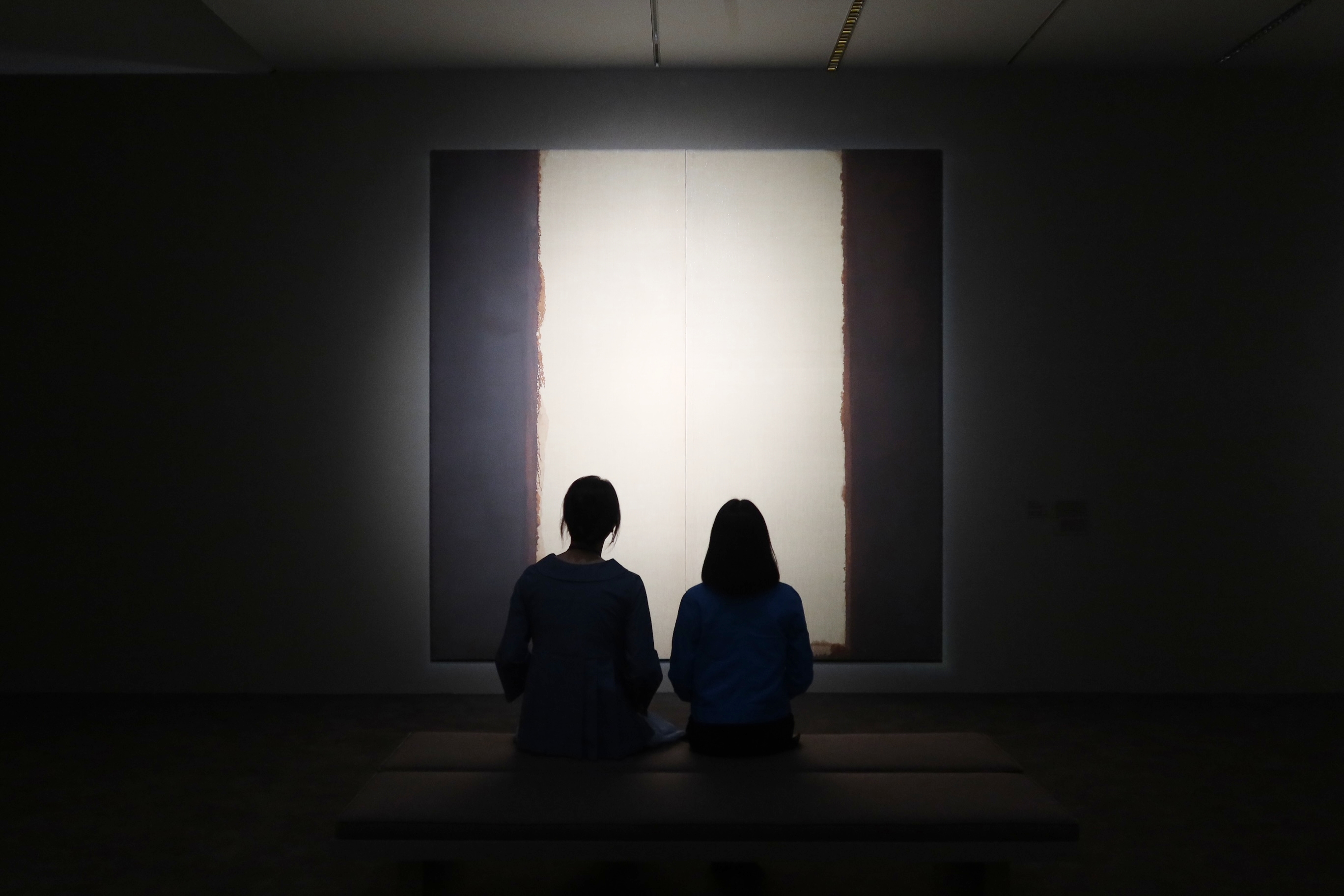 Dos personas contemplan 'Umber Blue 86‑29', obra de Yun Hyong‑keun, durante una rueda de prensa celebrada, el 25 de junio, un día antes de la inauguración de la exposición permanente 'Arte moderno y contemporáneo coreano II' en la sucursal del Museo Nacional de Arte Moderno y Contemporáneo de Corea (MMCA, por sus siglas en inglés) ubicada en Gwacheon, provincia de Gyeonggi‑do. | Fotos: Charles Audouin
