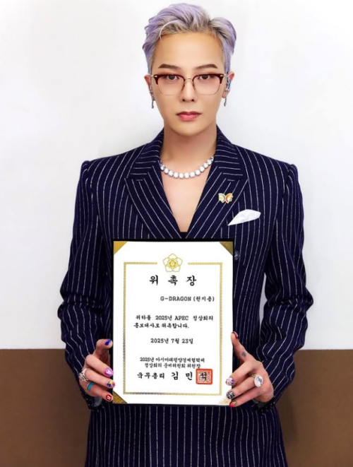 El artista de K-pop G-Dragon posa con su certificado de nombramiento como embajador promocional de la cumbre del APEC, en una imagen publicada el 23 de julio en sus redes sociales. |  Cuenta oficial de G-Dragon en Instagram