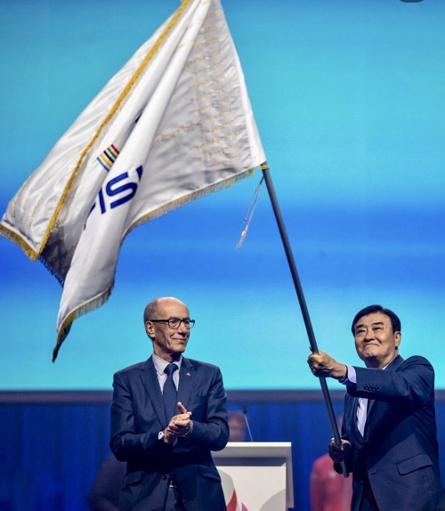 Kang Chang-hee, presidente del comité organizador de la Universiada de Verano de Chungcheong 2027, ondea la bandera junto al presidente de la Federación Internacional de Deporte Universitario (FISU, por sus siglas en francés), Leonz Eder, durante la ceremonia de clausura de los Juegos Mundiales Universitarios de Verano Rhine-Ruhr 2025, celebrada el 27 de julio (hora local) en Duisburgo, Alemania. | Cuenta oficial de la FISU en Instagram