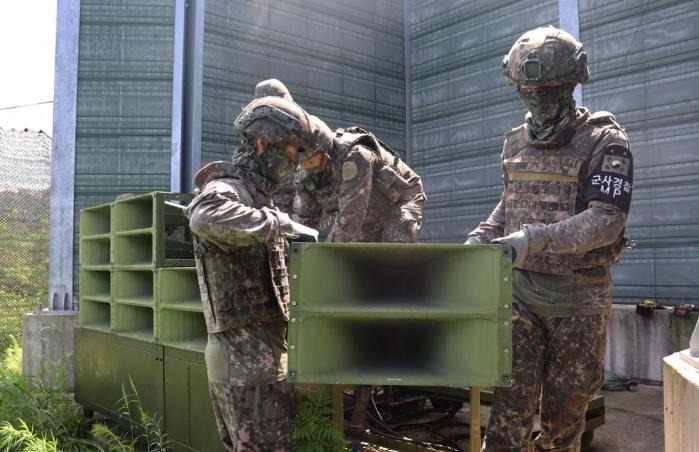 Unos soldados retiran equipos de sonido en una zona fronteriza intercoreana. | Ministerio de Defensa Nacional