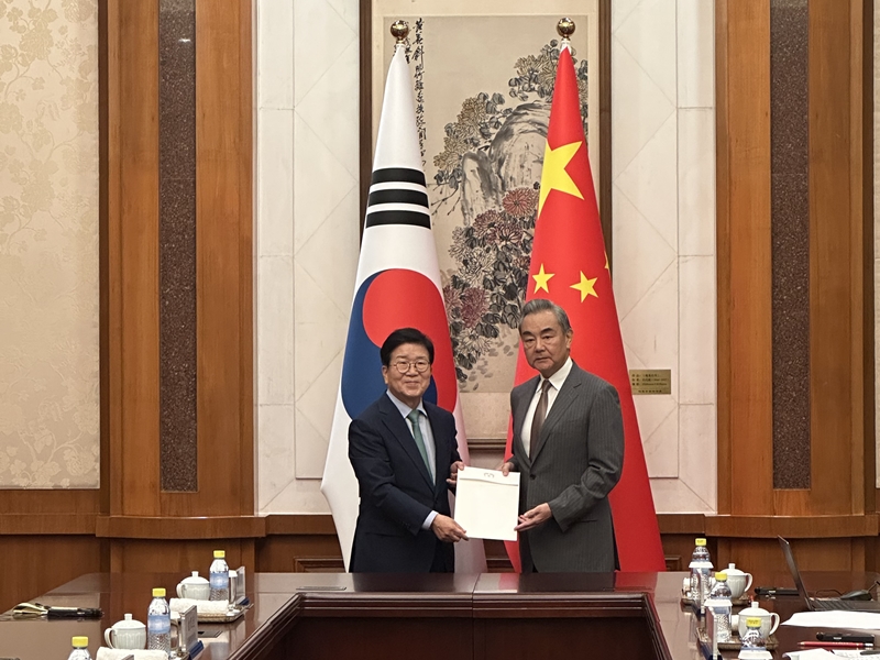Park Byeong-seug (izquierda), expresidente de la Asamblea Nacional y jefe del enviado presidencial especial a China, entrega el 24 de agosto la carta personal del presidente Lee Jae Myung al ministro de Asuntos Exteriores de China, Wang Yi, en la Casa de Huéspedes Estatales de Diaoyutai en Pekín. | Ministerio de Asuntos Exteriores de Corea
