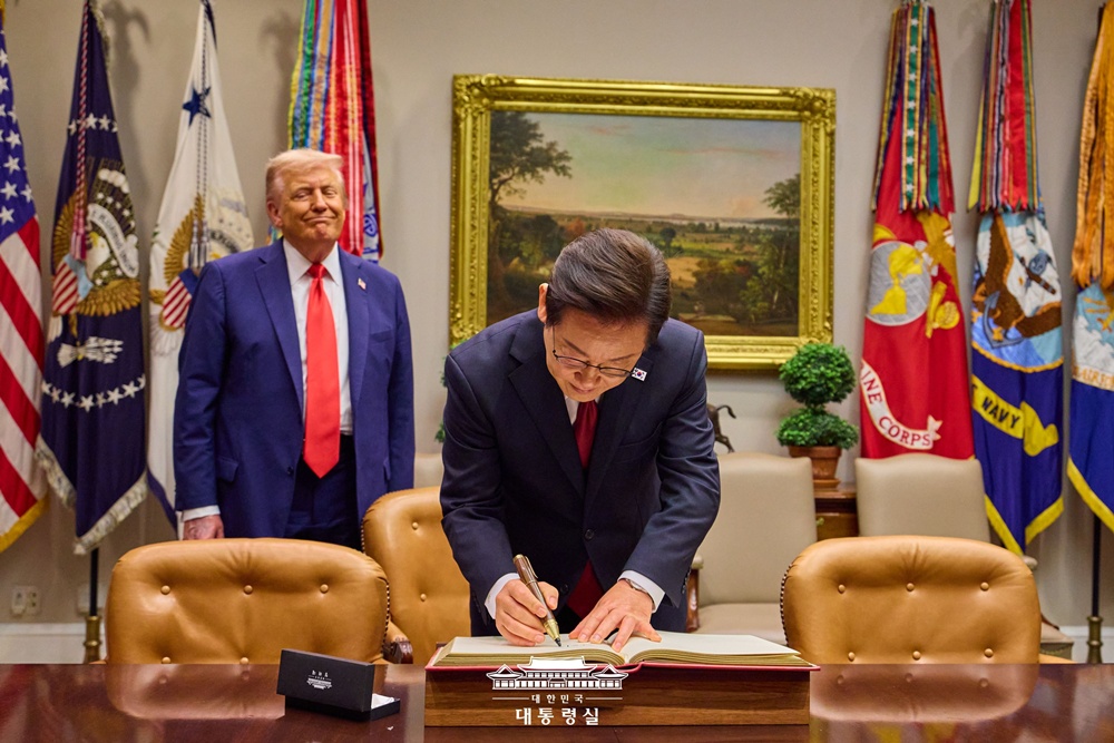 El presidente Lee Jae Myung firma el libro de visitas del Despacho Oval de la Casa Blanca, el 25 de agosto (hora local), en Washington D.C., acompañado por el presidente estadounidense Donald Trump. | Oficina presidencial