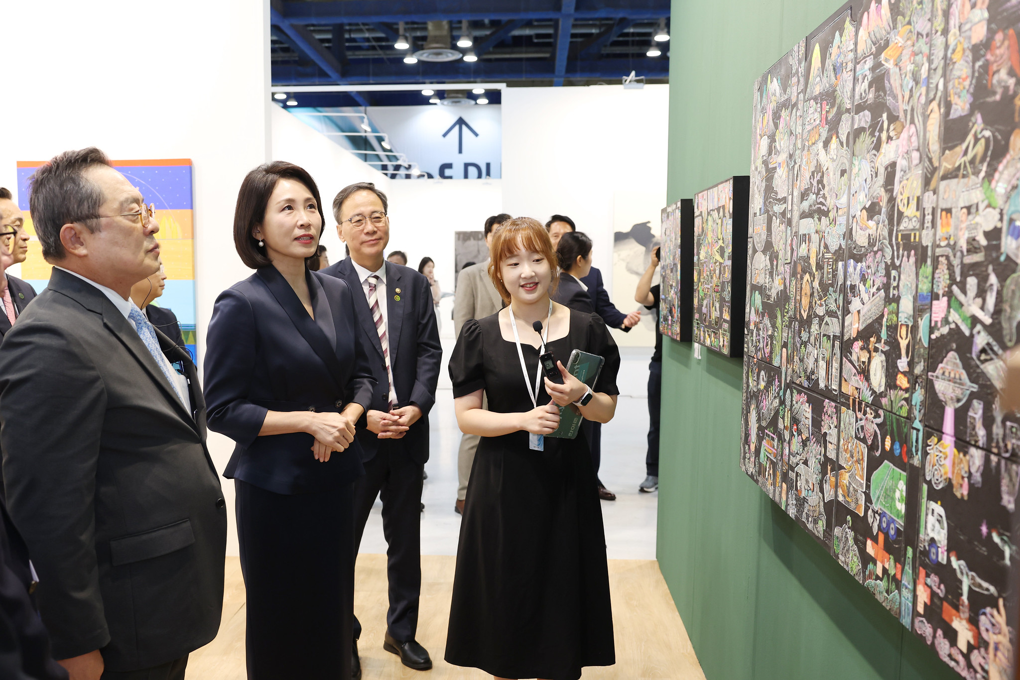 Kim Hea Kyung, esposa del presidente Lee Jae Myung, escucha la explicación de una obra el 3 de septiembre durante su visita a KIAF Seúl. | Lee Jeong Woo