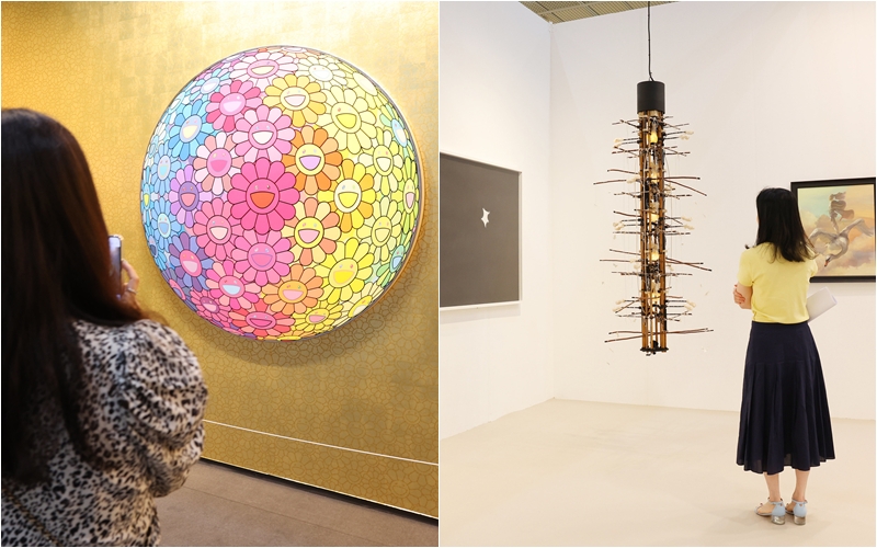 Un visitante contempla las obras presentadas el 3 de septiembre en KIAF y Frieze Seúl. A la izquierda, la pieza del artista Takashi Murakami expuesta en el estand de la galería Perrotin (Frieze); a la derecha, una obra de Yang Jung Uk presentada en el estand de Gallery Hyundai (KIAF). | Lee Jeong Woo