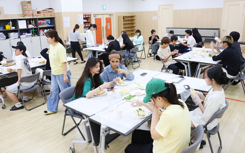 Unos jóvenes participan en la clase 'Educación para la Ciudadanía Mundial - Vietnam' en el auditorio del Centro Global de Educación Juvenil de Seúl, en el distrito de Yeongdeungpo-gu en Seúl, el 11 de septiembre, preparando sándwich vietnamita banh mi.