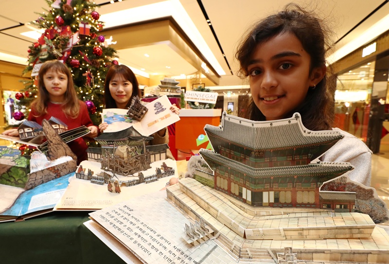 Una niña presenta un libro desplegable sobre los patrimonios culturales mundiales de Corea. | Agencia de Noticias Yonhap 