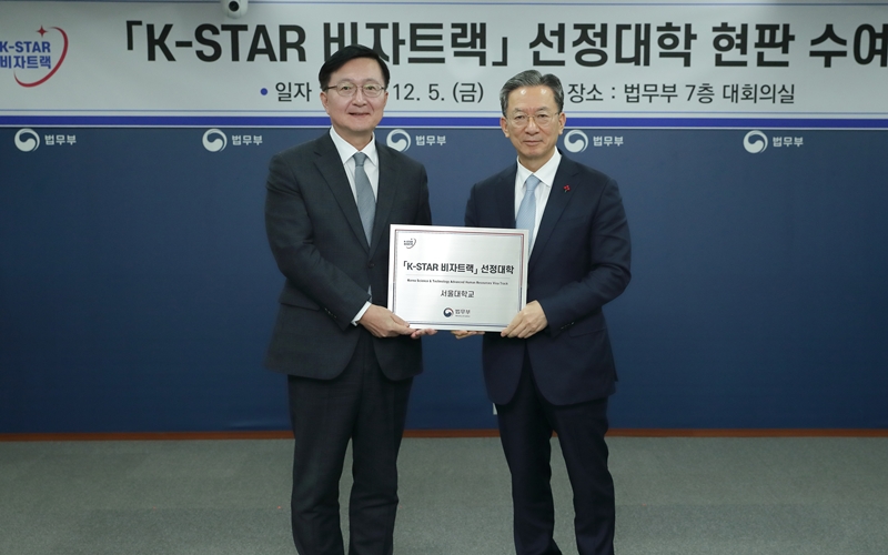 El ministro de Justicia, Jung Sung-ho (derecha), entrega una placa al rector de la Universidad Nacional de Seúl, Ryu Hong Rim, con motivo de la designación de la institución para la vía rápida para visados de talentos científicos y tecnológicos, durante una ceremonia celebrada el 5 de diciembre en el complejo cubernamental de Gwacheon, en la ciudad homónima en la provincia de Gyeonggi-do. | Ministerio de Justicia