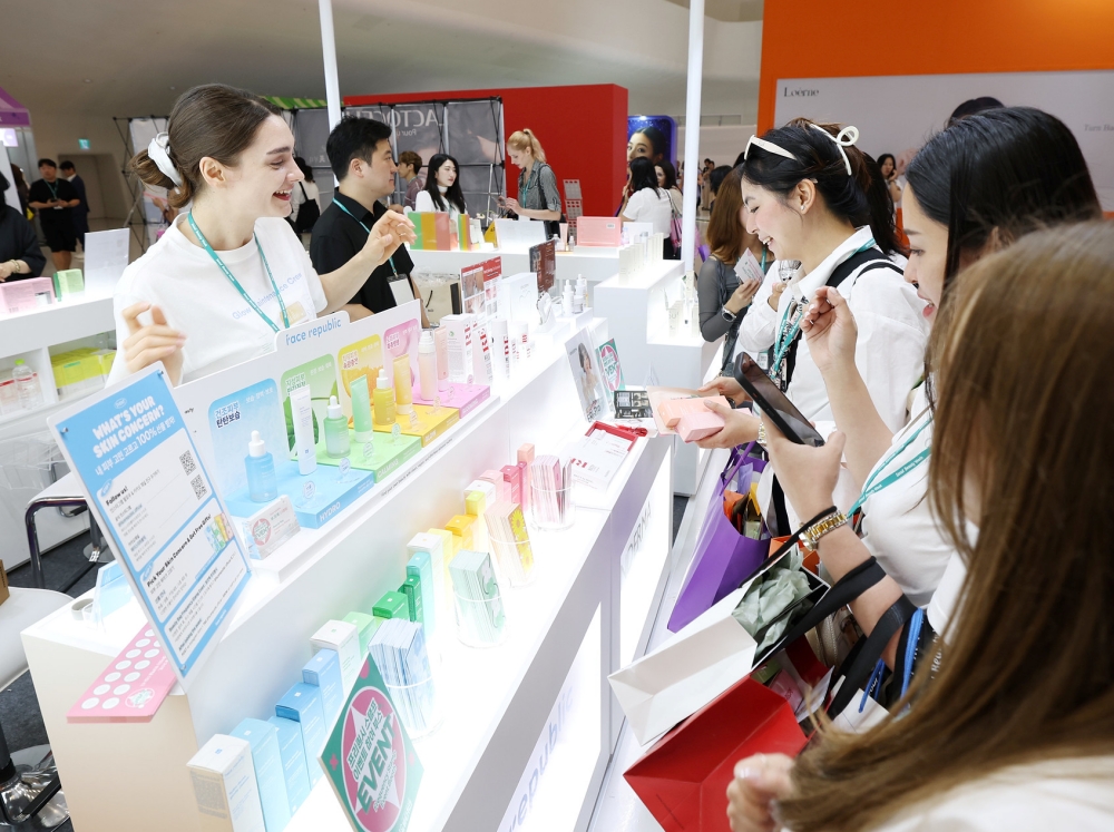 Unas visitantes reciben explicaciones sobre productos de cosmética durante la Seoul Beauty Week, celebrada el 28 de agosto de 2025 en la Plaza del Diseño de Dongdaemun (DDP, por sus siglas en inglés), en el distrito de Jung-gu, en Seúl. | Lee Jeong Woo