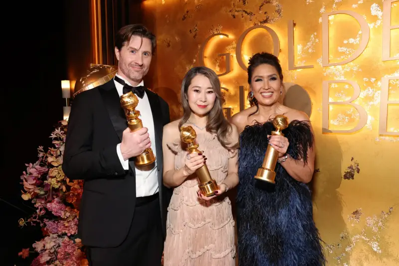 a creadora y codirectora de 'Las guerreras K-pop'. Maggie Kang (centro), el codirector Chris Appelhans (izquierda) y la productora Michelle Wong posan ante la c&aacute;mara, el 11 de enero (hora local), mientras sostienen sus premios globos de oro a la mejor pel&iacute;cula de animaci&oacute;n, en la ceremonia de entrega de premios celebrada en el hotel Beverly Hilton en Los &Aacute;ngeles, EE. UU..
