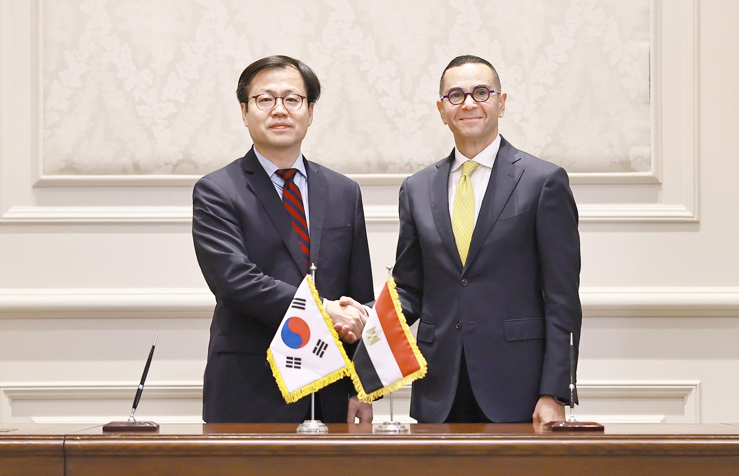 El jefe negociador de comercio de Corea, Yeo Han-koo (izda.), y el ministro egipcio de Inversi&oacute;n y Comercio Exterior, Hassan Elkhatib, se dan la mano tras firmar una declaraci&oacute;n conjunta para promover un Acuerdo de Asociaci&oacute;n Econ&oacute;mica Integral (CEPA), el 18 de enero (hora local), en El Cairo, Egipto. | Ministerio de Comercio, Industria y Recursos