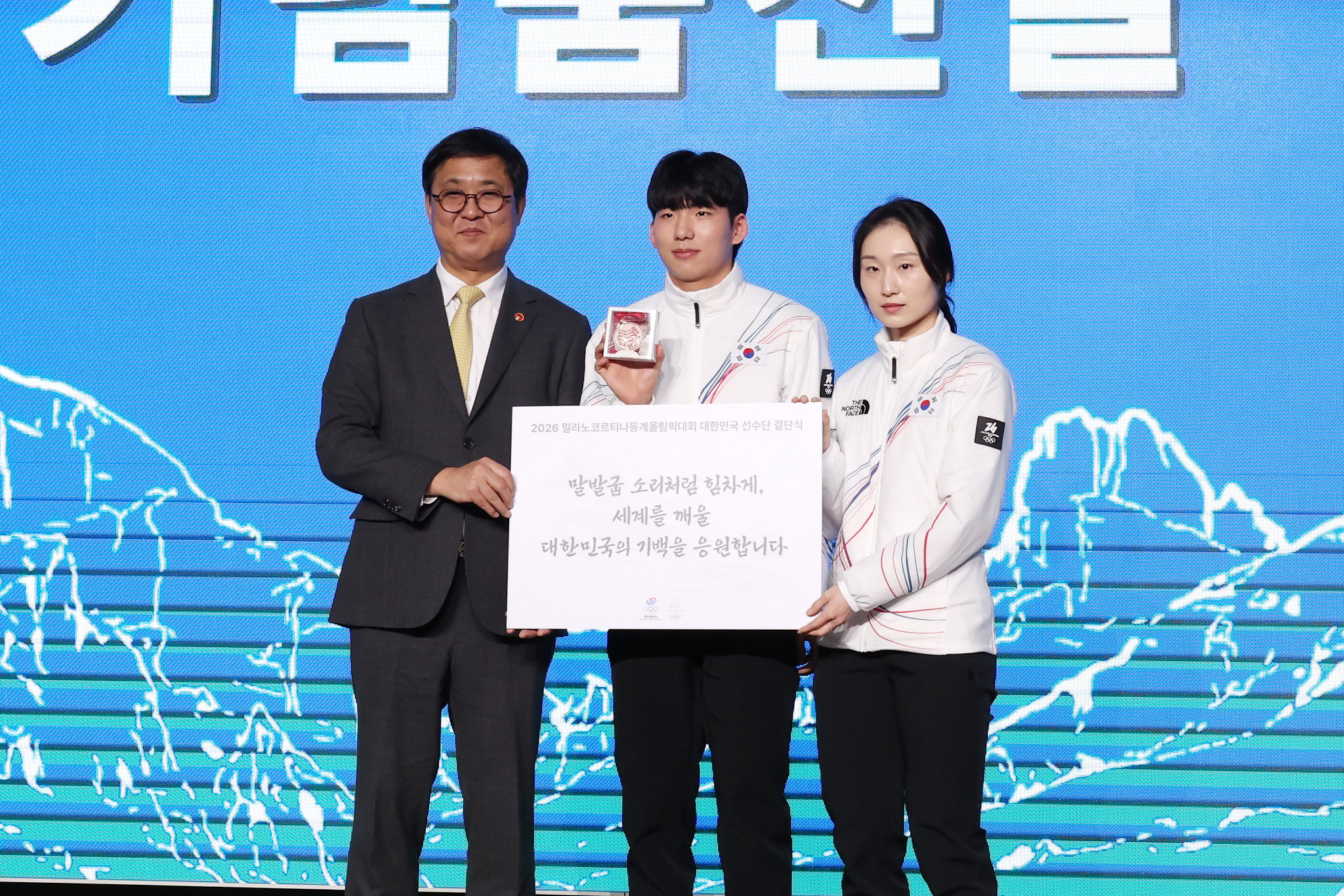 El ministro de Cultura, Deportes y Turismo, Chae Hwi-young (izda.), entrega mensajes de apoyo y reglaos a atletas que participarán en los próximos Juegos Olímpicos de Invierno durante la ceremonia de despedida del equipo nacional celebrada el 22 de enero, en el hotel Olympic Parktel, en el distrito de Songpa-gu, en Seúl. 