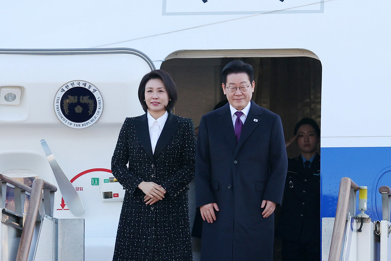 El 13 de enero, el presidente coreano Lee Jae Myung (dcha.) y la primera dama Kim Hea Kyung saludan a los presentes antes de abordar el avión presidencial en el aeropuerto de Seúl, en Seongnam, provincia de Gyeonggi-do,m en el marco de su visita a Japón. | Lee Jeong Woo
