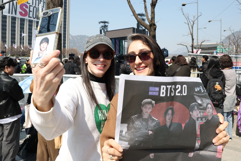 El 21 de marzo, a pocas horas del concierto 'BTS Comeback Live: ARIRANG', dos extranjeras se toman una foto, en la plaza Gwanghwamun, en el distrito de Jongno-gu, Seúl. | Lee Jeong Woo