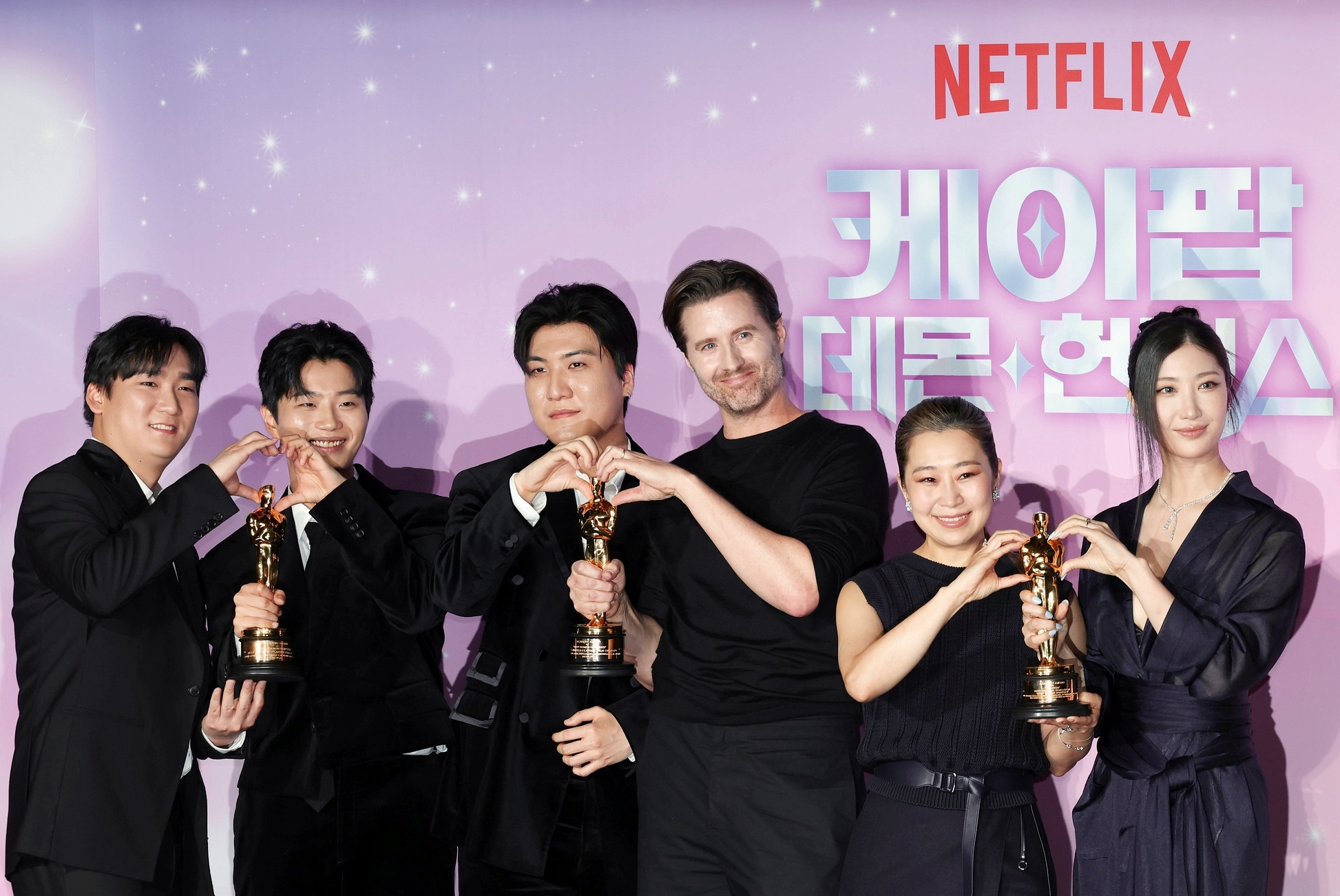 Los protagonistas de 'Las guerreras K-pop' posan con el trofeo dorado de los Óscar. De izquierda a derecha: los productores IDO (Nam Hee-dong, Lee Yu-han y Kwak Joong-kyu), el director Chris Appelhans, la directora Maggie Kang y la compositora y cantante EJAE. | Lee Jung Woo 