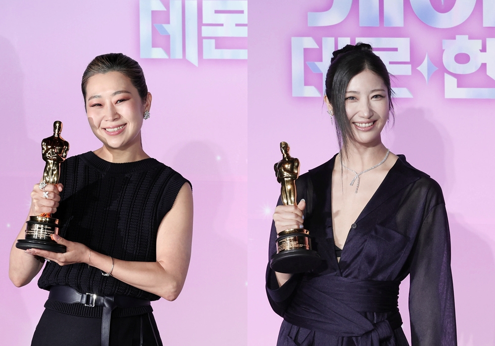 La directora de 'Las guerreras K-pop', Maggie Kang (izda.), y la cantautora EJAE posan con el trofeo ante la prensa coreana durante la rueda de prensa celebrada el 1 de abril en el cine múltiplex CGV Yongsan I’Park Mall, en el distrito de Yongsan-gu, en Seúl.