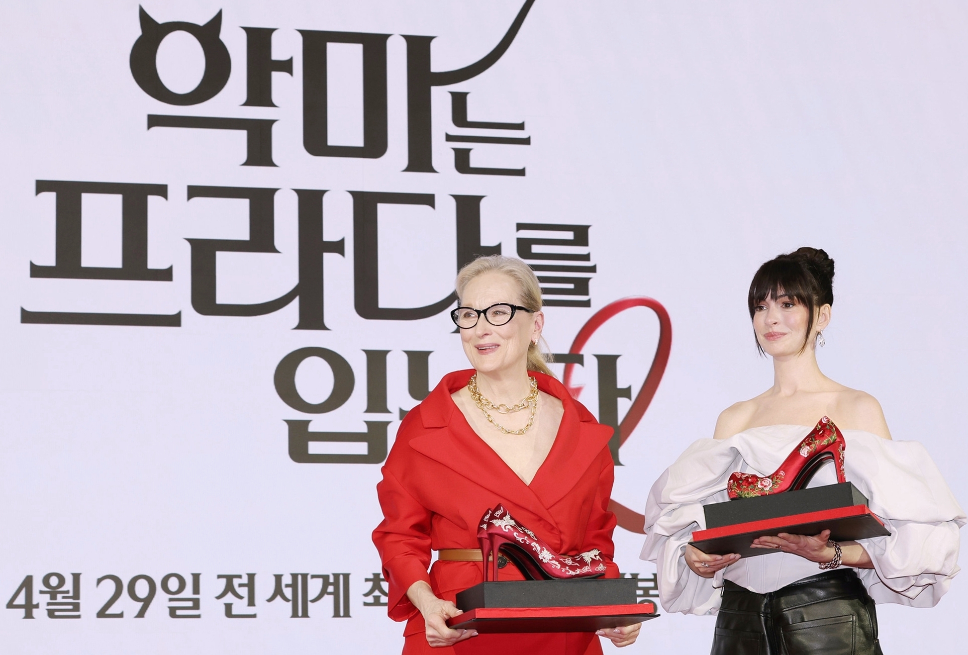 Las actrices estadounidenses Meryl Streep (izquierda) y Anne Hathaway posan para los medios tras recibir como obsequio unos tacones rojos inspirados en los zapatos tradicionales coreanos con motivos florales 'kkotsin', durante la rueda de prensa celebrada el 8 de abril en el hotel Four Seasons en Seúl, con motivo de su visita a Corea para promocionar su nueva película 'El diablo viste de Prada 2'. | Lee Jeong Woo