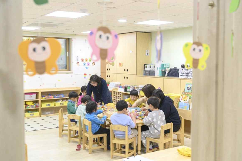 Un grupo de educadoras realiza actividades lúdicas con niños en una 'Guardería de Emergencia Nocturna de Yangcheon', ubicada en el distrito homónimo de Seúl. Este distrito ha ampliado su sistema de cuidado nocturno a 27 instalaciones para cubrir brechas inesperadas en el cuidado infantil. | Distrito de Yangcheon-gu