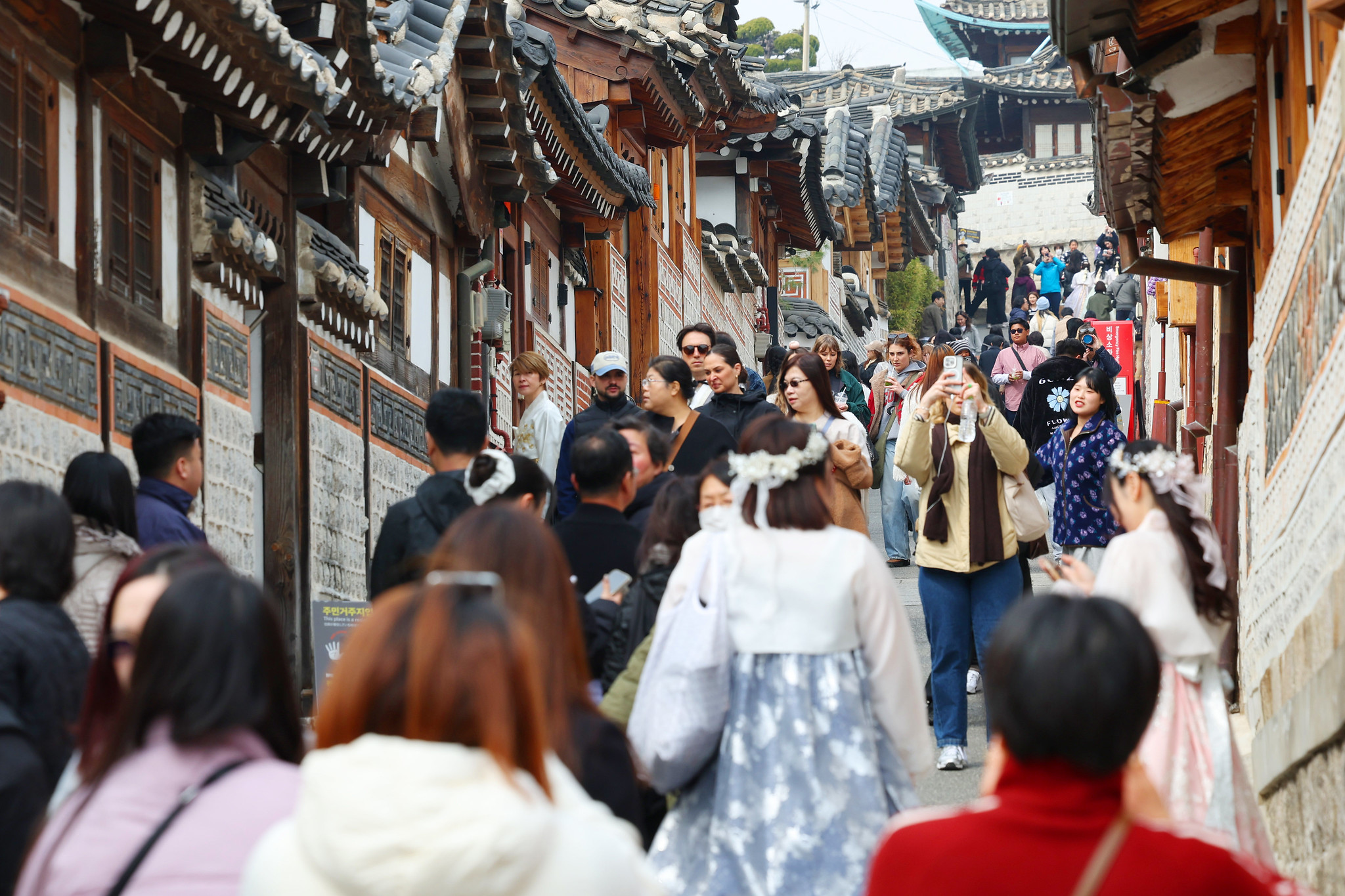 El 16 de marzo, una multitud de turistas extranjeros recorre la aldea de casas tradicionales de Bukchon, situada en el distrito de Jongno-gu, en Seúl. | Lee Jeong Woo