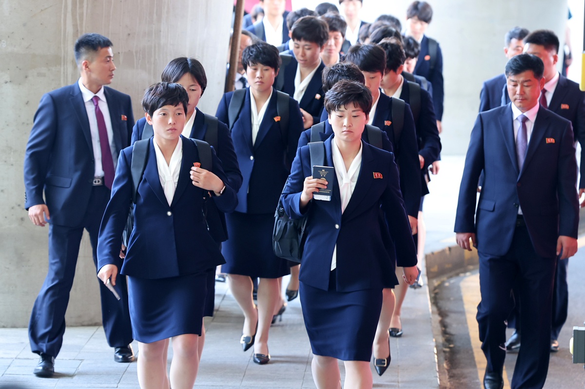 Las integrantes del equipo de f&uacute;tbol femenino norcoreano Naegohyang Women's FC se dirigen a un autob&uacute;s tras llegar a la Terminal 1 del Aeropuerto Internacional de Incheon, el 17 de mayo. | Agencia de Noticias Yonhap