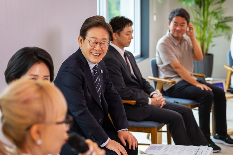 El presidente Lee Jae Myung sonríe mientras escucha las intervenciones de unos artistas, durante un evento celebrado el 30 de junio de 2025, en el jardín delantero de la oficina presidencial en Yongsan, Seúl.