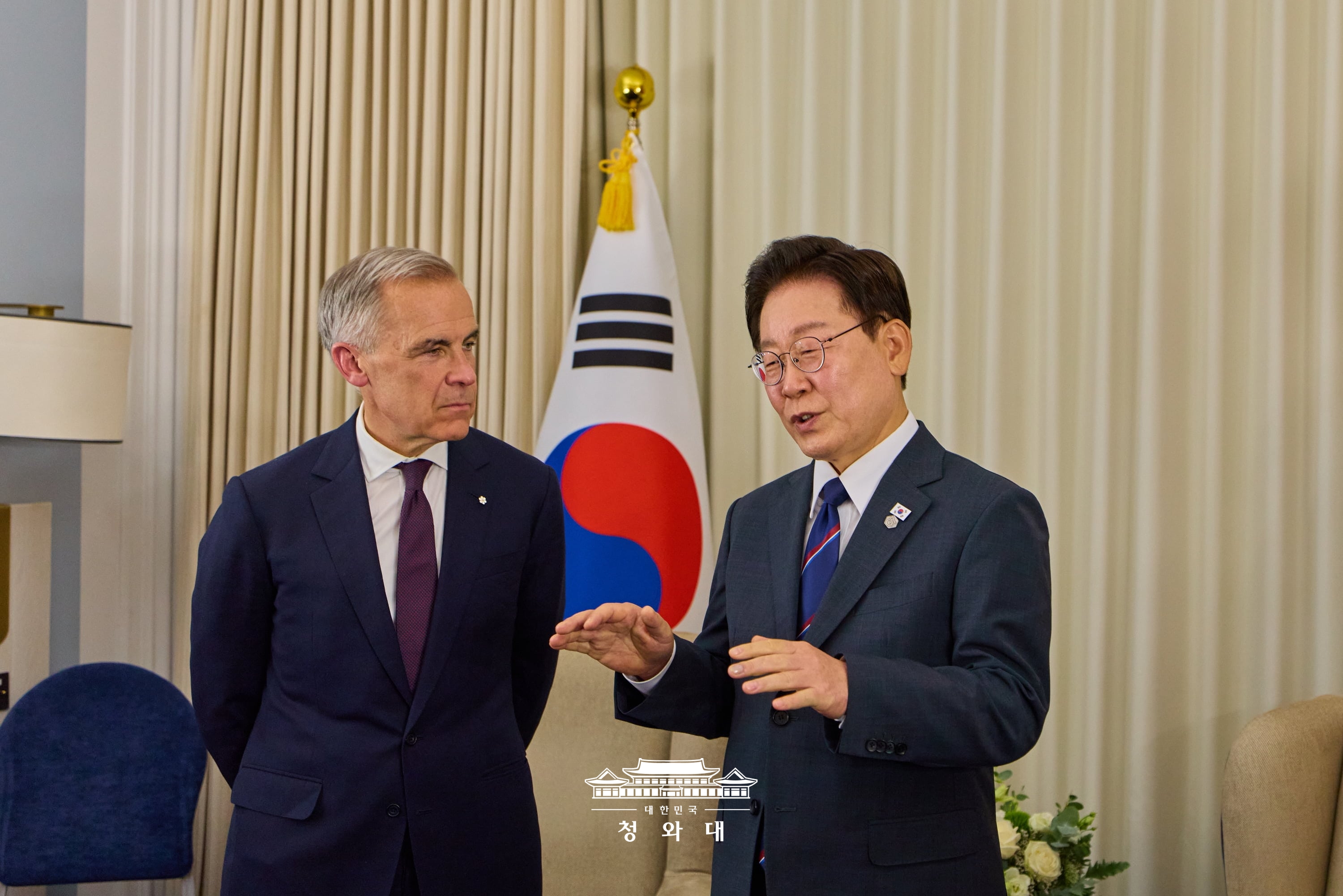 El presidente coreano, Lee Jae Myung (derecha), y el primer ministro canadiense Mark Carney mantienen una reuni&oacute;n bilateral el 16 de junio (hora local) en &Eacute;vian-les-Bains, Francia, sede de la cumbre del G7. 