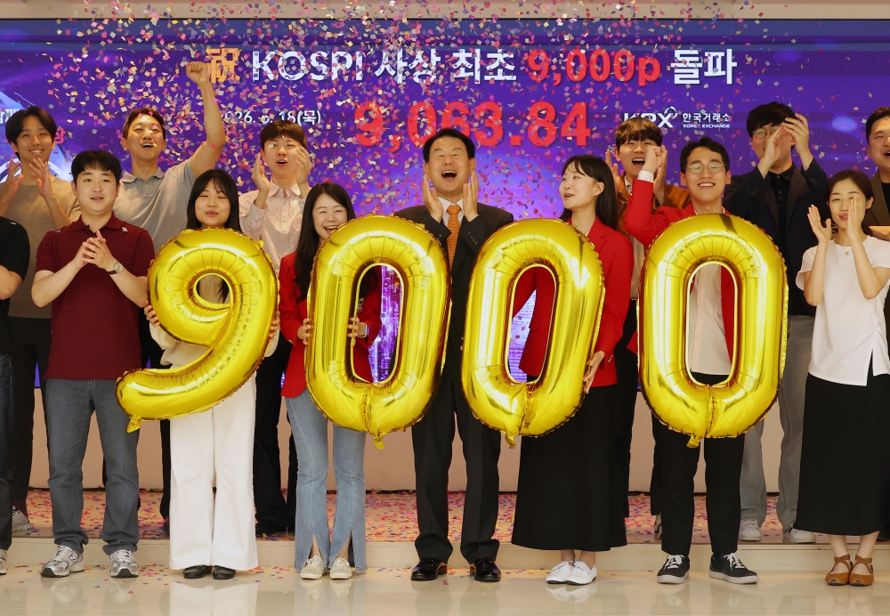 Los empleados de la Bolsa de Valores de Corea (KRX, por sus siglas en inglés) celebran que el Índice Compuesto de Precio Bursátil de Corea (KOSPI) alcanzara un máximo histórico de 9.063,84, el 18 de junio, en la sede de Busan. | Agencia de Noticias Yonhap