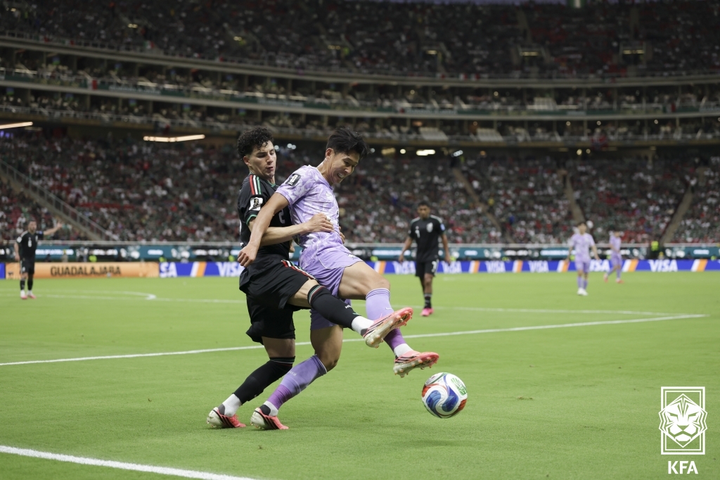 Son Heung-min, el capitán de la selección nacional de fútbol de Corea, controla el esférico protegiéndolo de la marca de un defensor mexicano, durante el partido disputado el 18 de junio (hora local), en el Estadio Akron de Guadalajara, en México. | Asociación de Fútbol de Corea