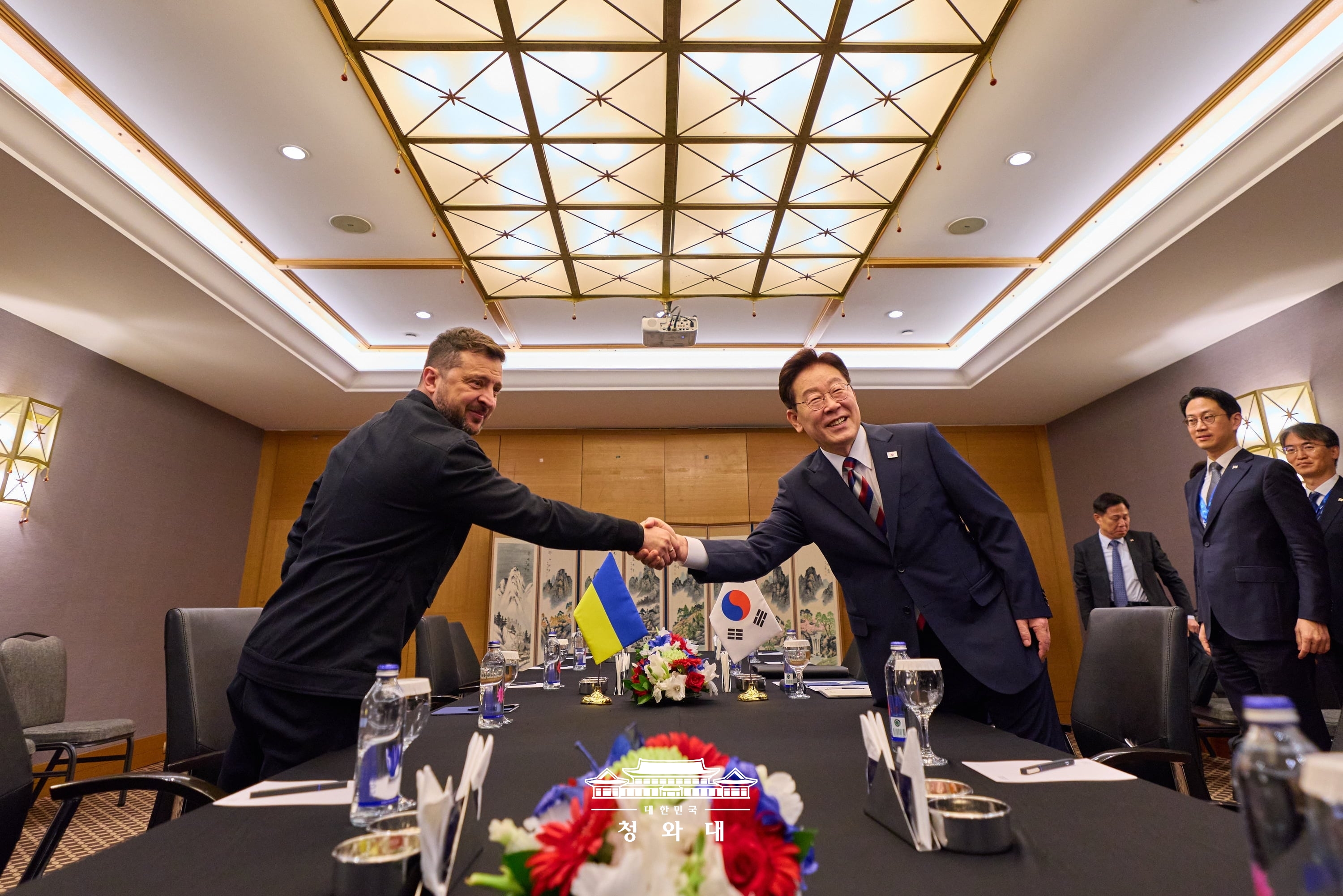 El presidente coreano Lee Jae Myung (dcha.) estrecha la mano de su homólogo ucraniano, Volodímir Zelenski, durante la cumbre bilateral celebrada el 8 de julio (hora local), en un hotel de Ankara, en Turquía.