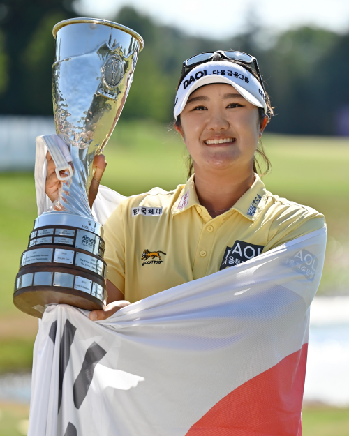 La golfista coreana Ryu Haeran sonríe mientras sostiene su trofeo del Amundi Evian Championship —el 4º torneo major del Campeonato de la PGA Femenino—, celebrado 12 de julio (hora local), en el Evian Resort Golf Club en Évian-les-Bains, en Francia.  