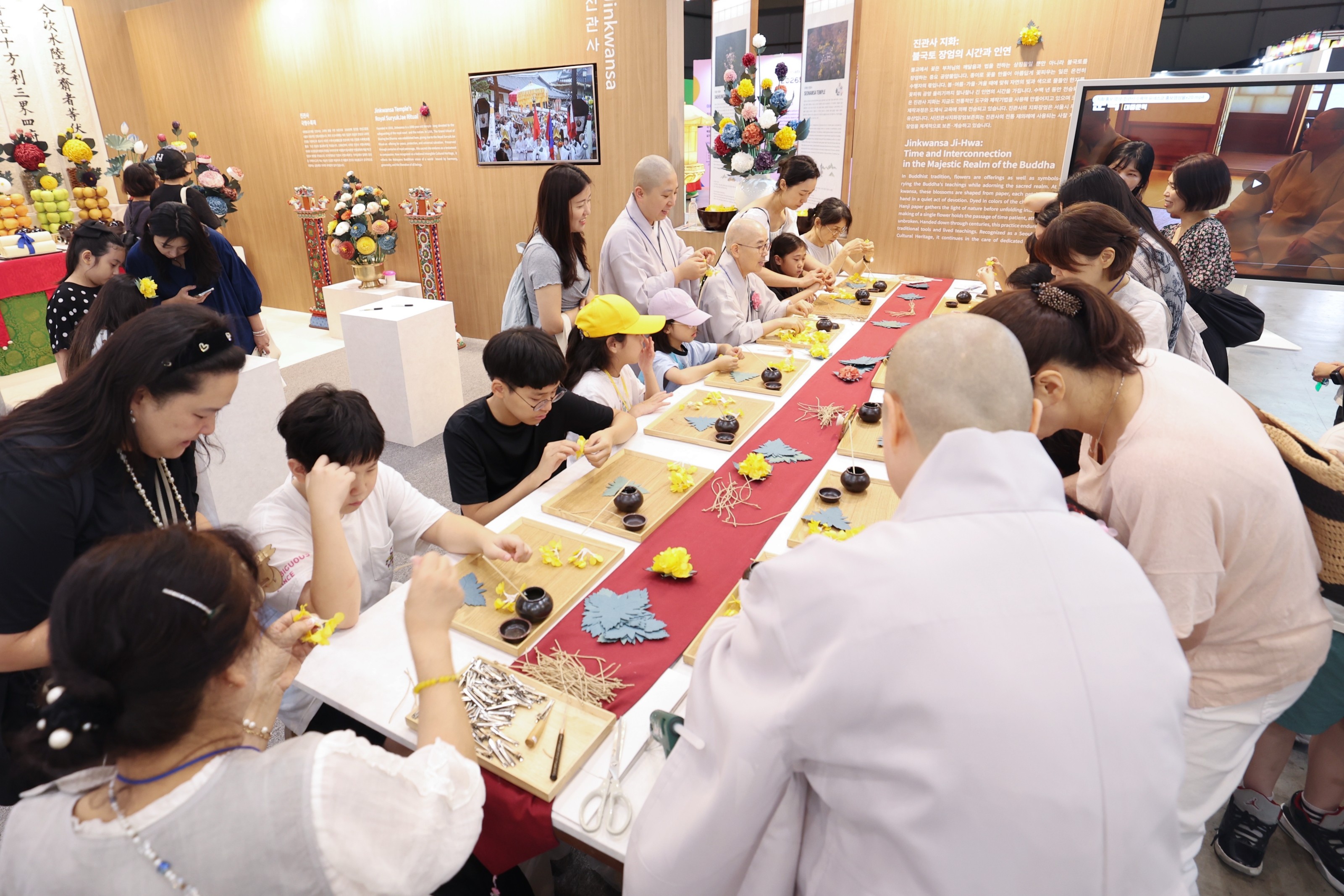 Los visitantes aprenden a elaborar jihwa (flores de papel tradicionales) en un taller impartido el 23 de julio en el puesto del templo Jingwansa, instalado dentro del Pabell&oacute;n de la Rep&uacute;blica de Corea', en la Sala de Exposiciones 1 del Centro de Exposiciones y Convenciones de Busan (BEXCO, por sus siglas en ingl&eacute;s).