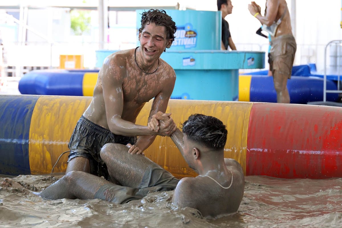 Unos turistas se divierten el 24 de julio en la piscina de barro de la playa de Daecheon, en Boryeong, en la provincia de Chungcheong-do, durante la jornada inaugural del Festival del Barro de Boryeong. | Agencia de Noticias Yonhap