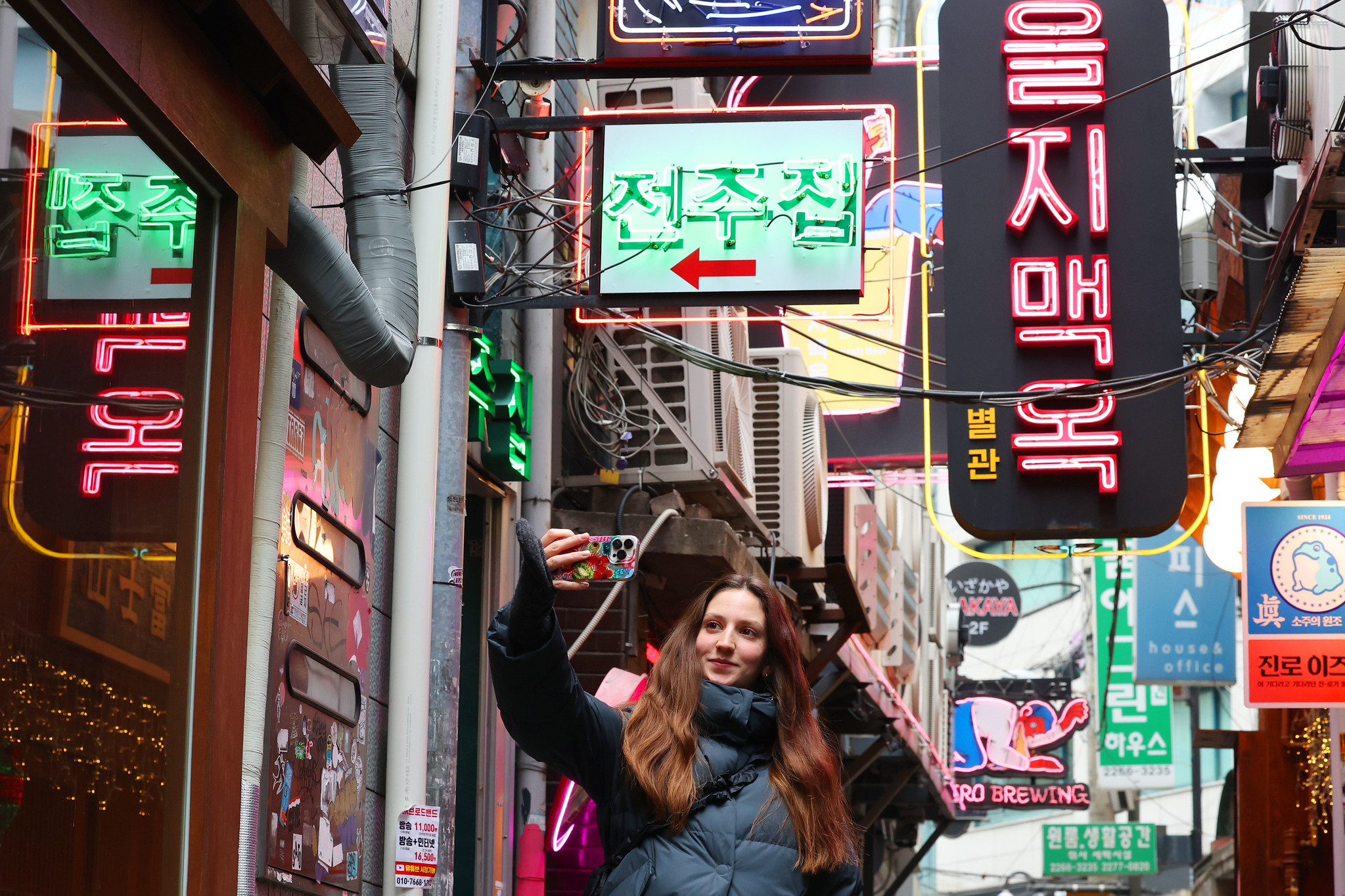 La imagen, tomada a finales de 2025, muestra a una turista extranjera tom&aacute;ndose una foto en un callej&oacute;n del distrito de Jung-gu, en Se&uacute;l. | Korea.net DB 