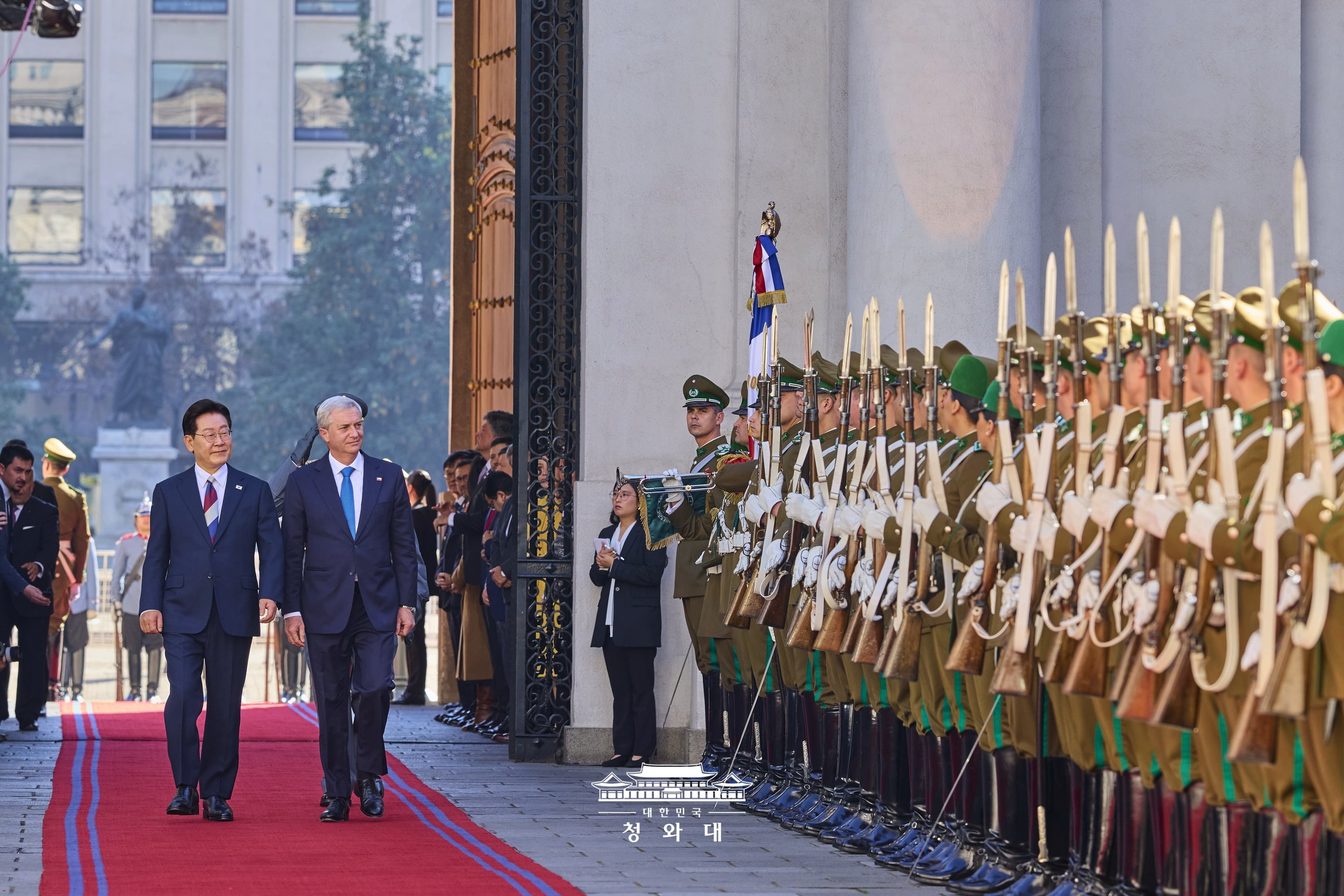 El presidente Lee Jae Myung (izda.)&mdash;el primer mandatario coreano en visitar Chile en 11 a&ntilde;os&mdash; camina frente a la guardia de honor junto a su homologo chileno, Jos&eacute; Antonio Kast, durante la ceremonia oficial de bienvenida, celebrada el 30 de julio (hora local), en el Palacio de La Moneda, en Santiago. En la cumbre bilateral posterior, ambos l&iacute;deres acordaron reactivar la Comisi&oacute;n de Libre Comercio Corea-Chile de nivel ministerial, que hab&iacute;a estado suspendida durante 10 a&ntilde;os, e impulsaron la modernizaci&oacute;n del Tratado de Libre Comercio (TLC) bilateral y el fortalecimiento de su 'asociaci&oacute;n estrat&eacute;gica'. Asimismo, ambas naciones firmaron cinco memorandos de entendimiento (MOU, por sus siglas en ingl&eacute;s), incluido el MOU sobre la asociaci&oacute;n en recursos minerales con Chile, una potencia mineral a nivel mundial. Tambi&eacute;n acordaron elevar el Comit&eacute; de Cooperaci&oacute;n en Recursos al rango ministerial, ampliando sustancialmente la cooperaci&oacute;n pr&aacute;ctica en las cadenas de suministro de minerales cr&iacute;ticos y en las industrias del futuro.