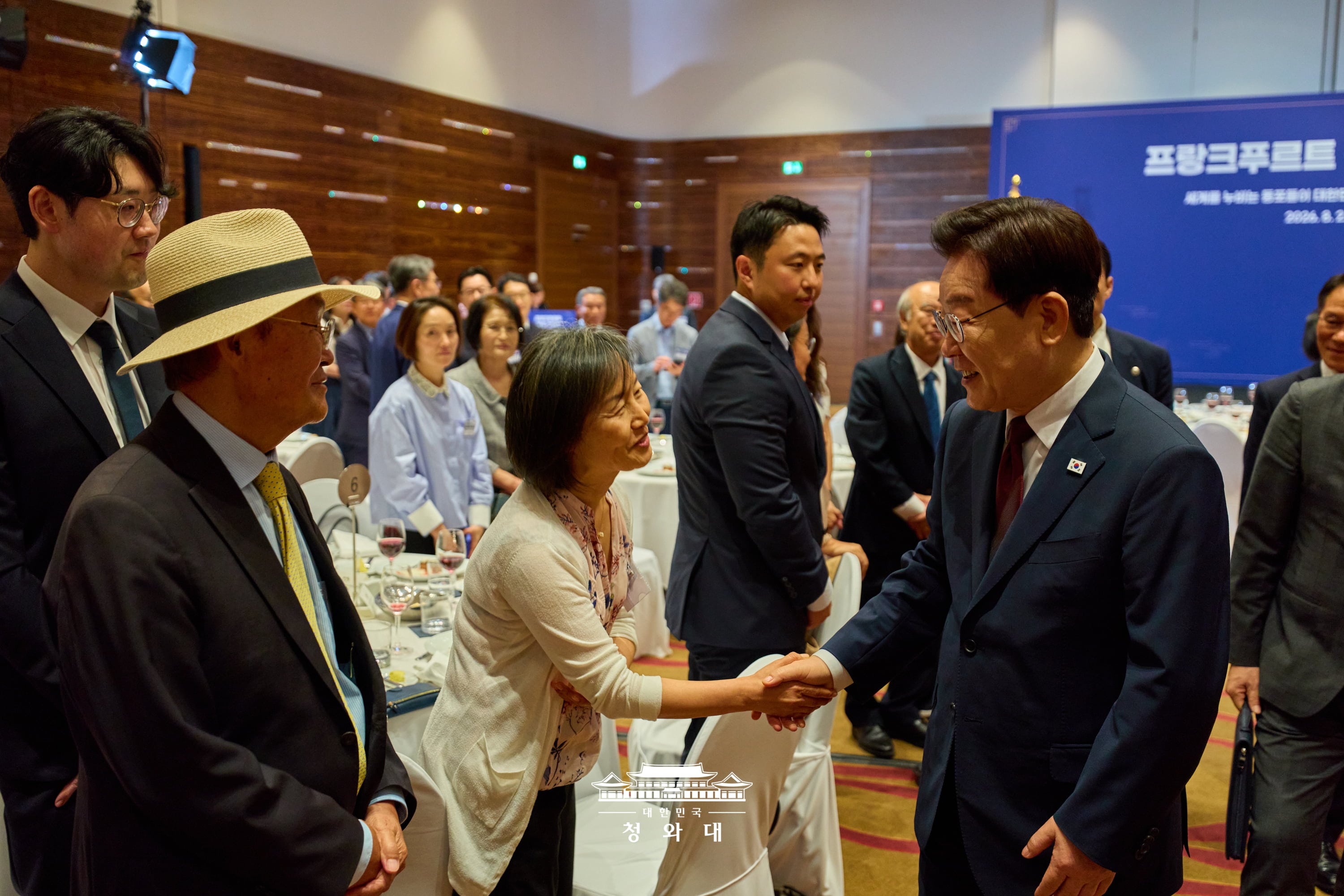 El presidente Lee Jae Myung (dcha.), quien lleg&oacute; a Alemania en la &uacute;ltima etapa de su gira, da un apret&oacute;n de manos a una coreana residente en Alemania durante el encuentro con la comunidad de coreanos residentes celebrado el 2 de agosto (hora local) en un hotel de Fr&aacute;ncfort, manteniendo un estrecho y c&aacute;lido di&aacute;logo con los presentes.
