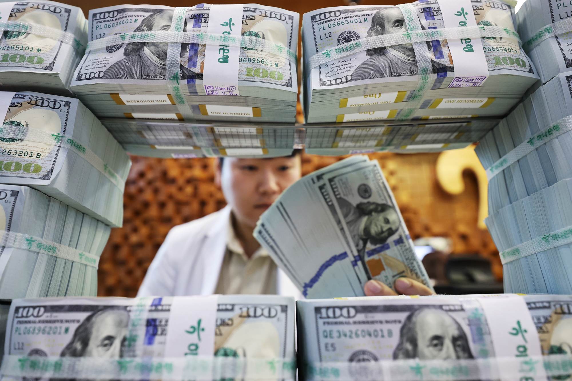 La foto, tomada el 5 de agosto, muestra a un empleado organizando d&oacute;lares, en el Centro de An&aacute;lisis e Identificaci&oacute;n de Falsificaciones del Banco Hana, ubicado en el distrito de Jung-gu, en Se&uacute;l. | Agencia de Noticias Yonhap