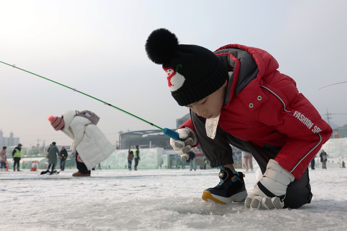 Un ni&ntilde;o observa el agujero de pesca durante el Festival de Hielo Hwacheon Sancheoneo, celebrado del 10 de enero al 1 de febrero en el arroyo Hwacheoncheon, en la localidad de Hwacheon, provincia de Gangwon-do. | Koreanet DB