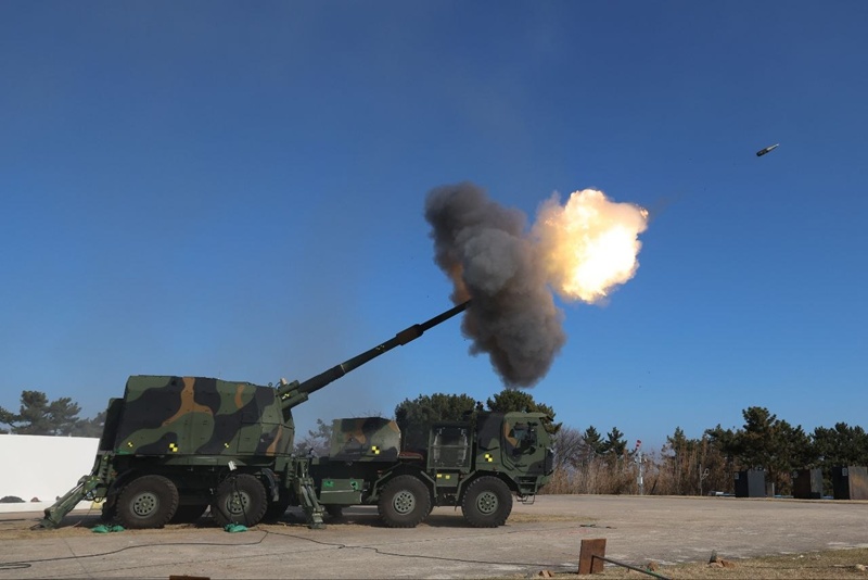 Un ob&uacute;s autopropulsado sobre ruedas K9 (K9MH) realiza una prueba de tiro en el campo de pruebas de la Agencia para el Desarrollo de la Defensa (ADD). | Hanwha Aerospace 