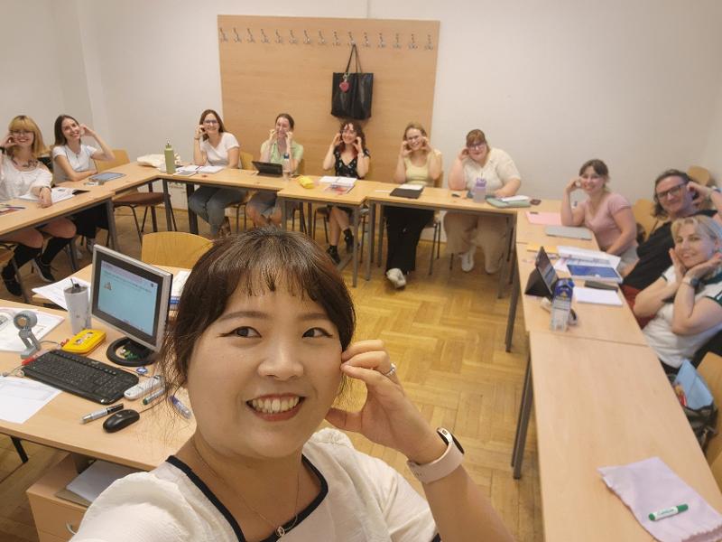 La profesora Park Insun posa para un selfi grupal con sus estudiantes durante un curso de coreano pr&aacute;ctico en la sede del Instituto Rey Sejong en Budapest, Hungr&iacute;a, antes de la ceremonia de graduaci&oacute;n del segundo semestre de 2025. | Park Insun