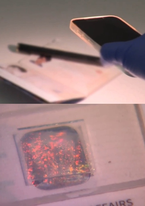 En la imagen superior se observa la linterna de un tel&eacute;fono alumbrando la nanohuella colocada en un pasaporte; en la inferior se aprecia el reflejo singular e infalsificable que proyecta el material.