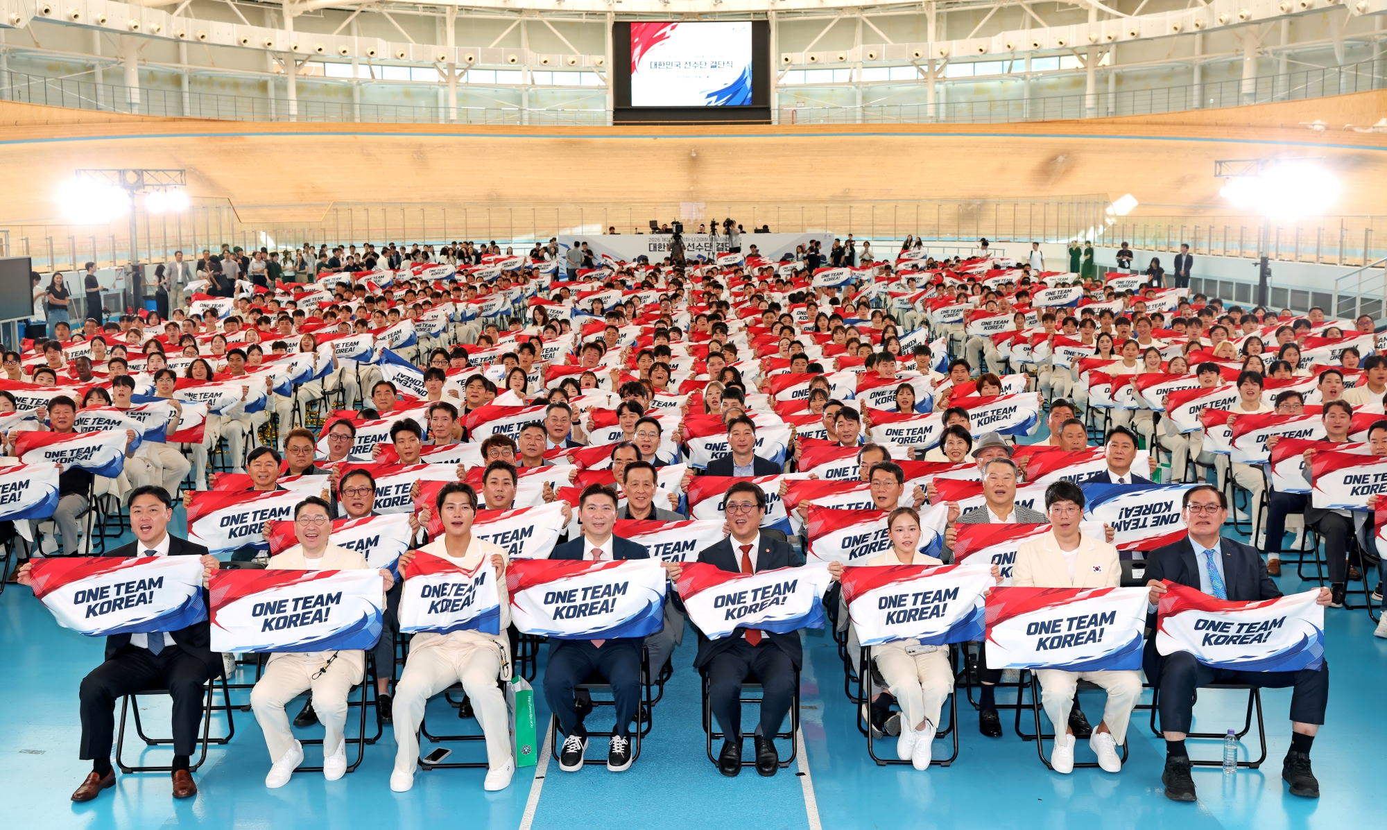 Los asistentes, incluido el ministro de Cultura, Deportes y Turismo, Chae Hwi-young (cuarto desde la derecha en la primera fila), se toman una foto conmemorativa durante la ceremonia de juramento celebrada el 3 de septiembre en el vel&oacute;dromo del Centro Nacional de Entrenamiento de Jincheon, ubicado en el condado de Jincheon-gun, provincia de Chungcheongbuk-do. | Ministerio de Cultura, Deportes y Turismo